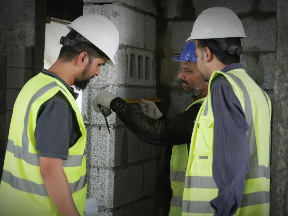 مهندسون يقيسون جداراً من البلوك